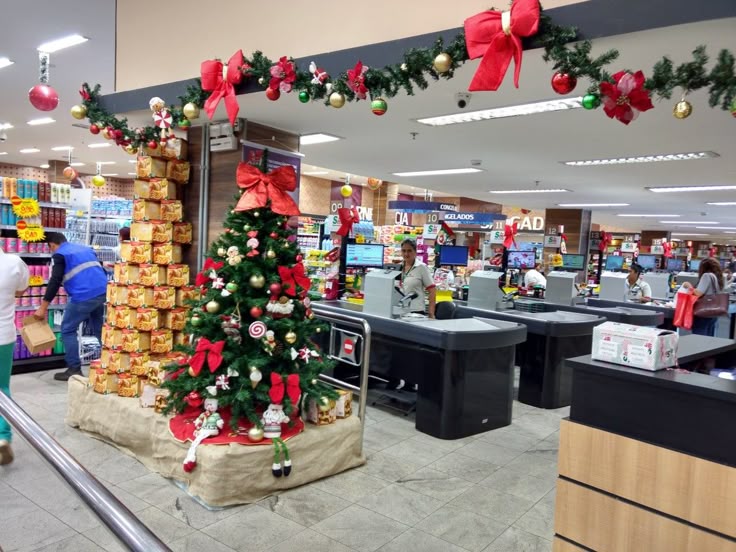 Supermarket decorated with a Christmas tree and red bows near checkout lanes