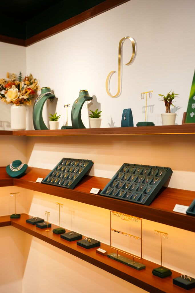 Pristine Paradigm logo mounted on showroom wall above green jewelry display trays